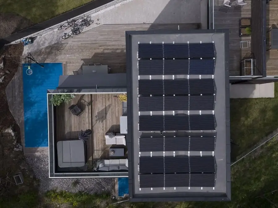 fågelvy över villa med solpaneler på platt tak